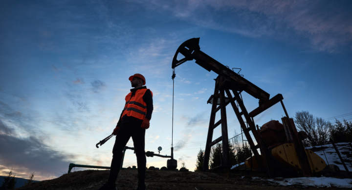 silhouette-of-a-worker-and-an-oil-pump-jack-on-the-sunset-agains-beautiful-sky