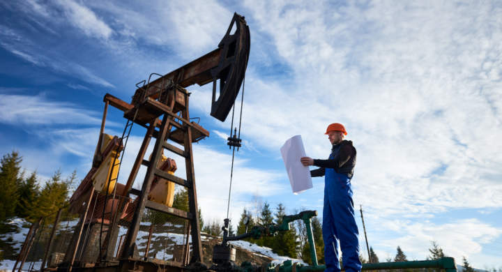 oil-worker-standing-by-oil-well-pump-jack