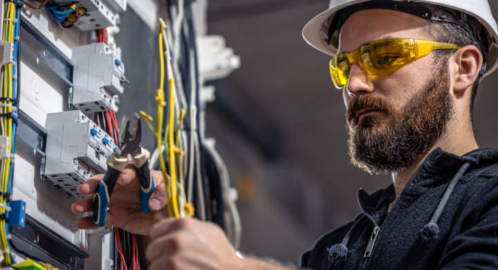 a-male-electrician-works-in-a-switchboard-with-an-electrical-connecting-cable