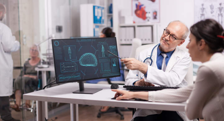 Doctor explaining x-ray for sick patient in hospital office before brain surgery. Disabled mature woman in wheelchair discussing with young radiologist.