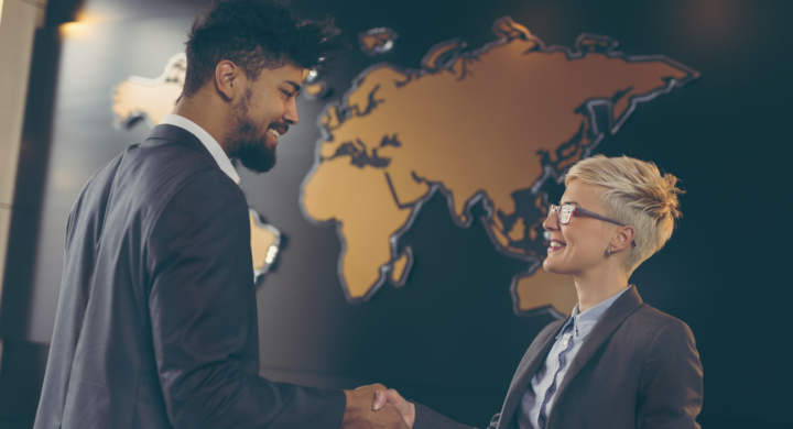 Businessman and business woman shaking hands after achieving agreement and signing contract