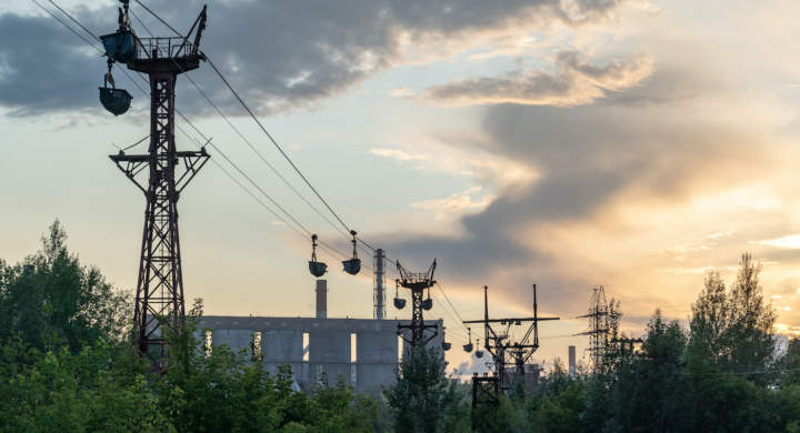 An industrial ropeway for transportation of raw materials against the cloudy sunset sky