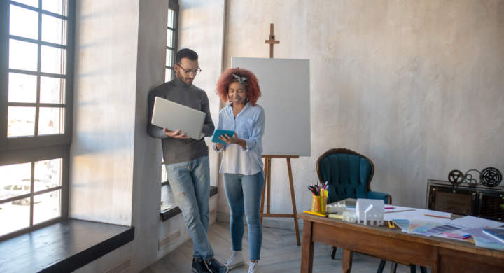 Modern spacious office. Two interior designers enjoying work in modern spacious office
