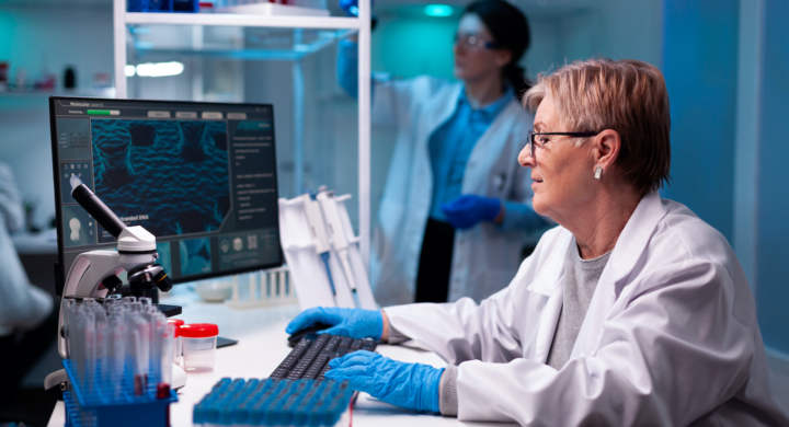 Senior scientist researcher engineering vaccine with team in pharmacology chemical facility. Doctor examining vaccine evolution using high tech for scientific research, treatment development.