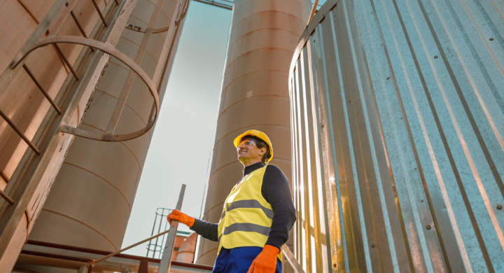 cheerful-male-worker-standing-on-stairs-at-factory
