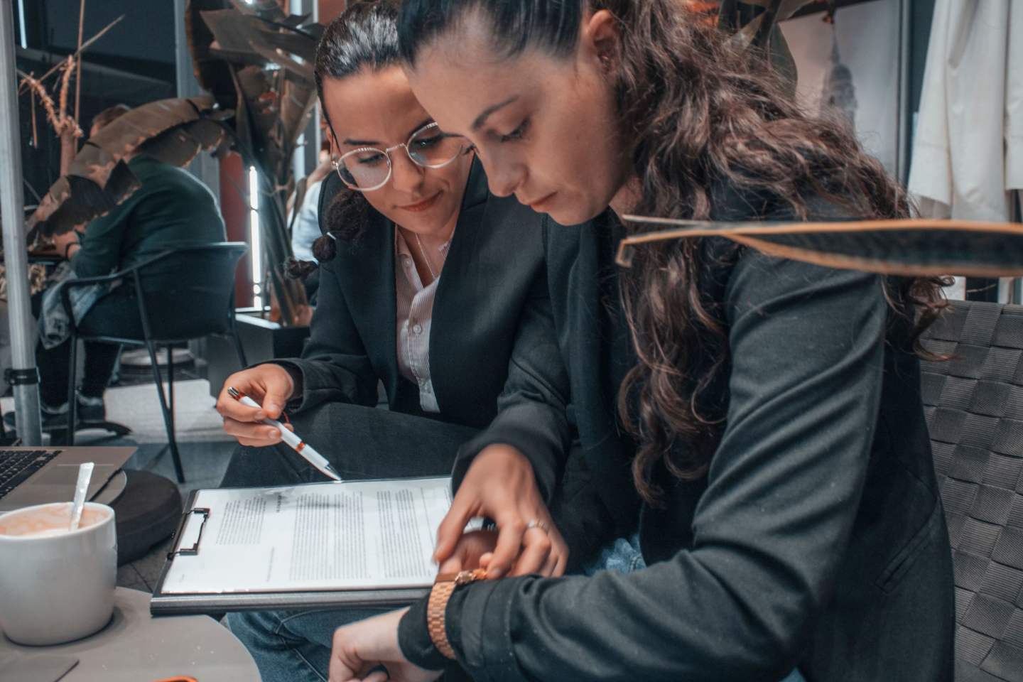 The view of two young colleagues students working on a task while sitting in the cafeteria
