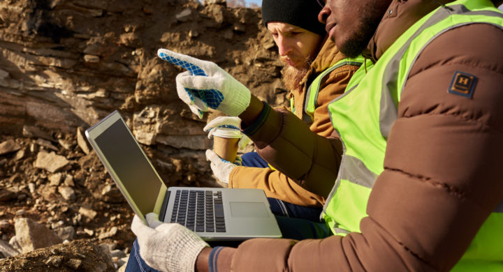 Mining Workers Using Laptop on Excavation Site