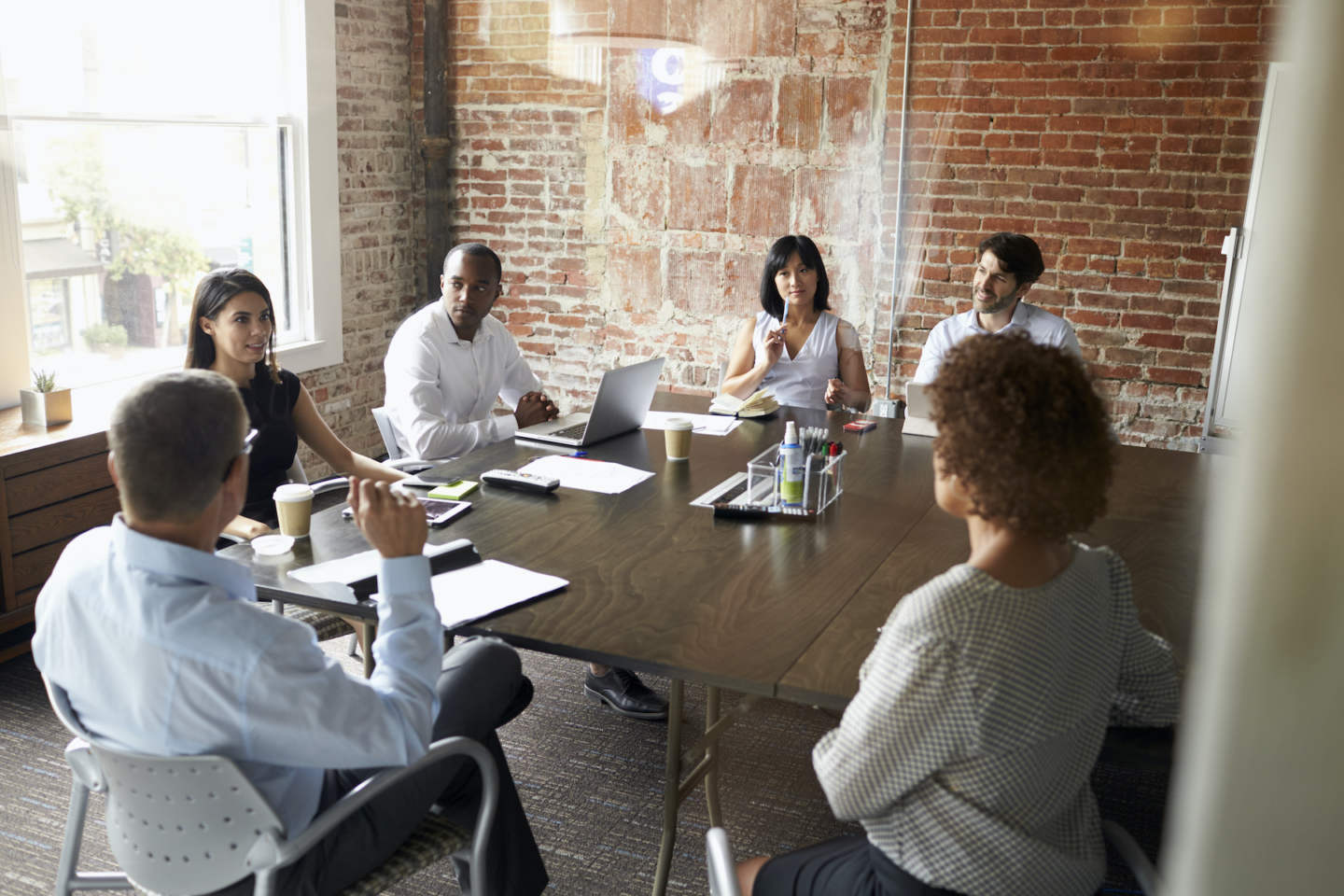 Group Of Businesspeople Meeting In Modern Boardroom