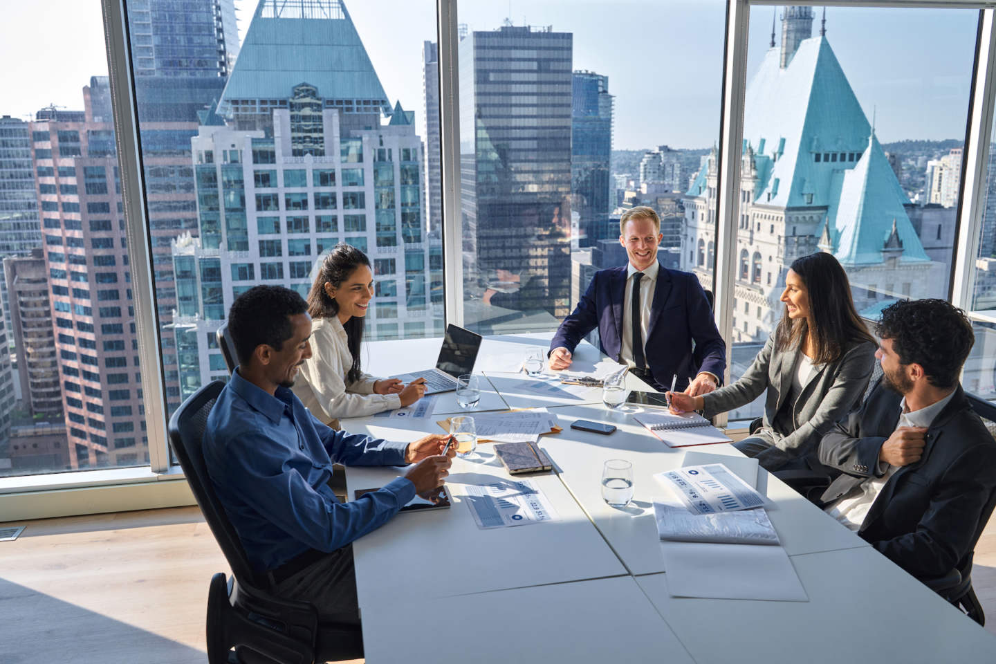 International happy professional business team consulting at group meeting. Multicultural busy coworkers working together in teamwork discussing project managing work plan in office board room.
