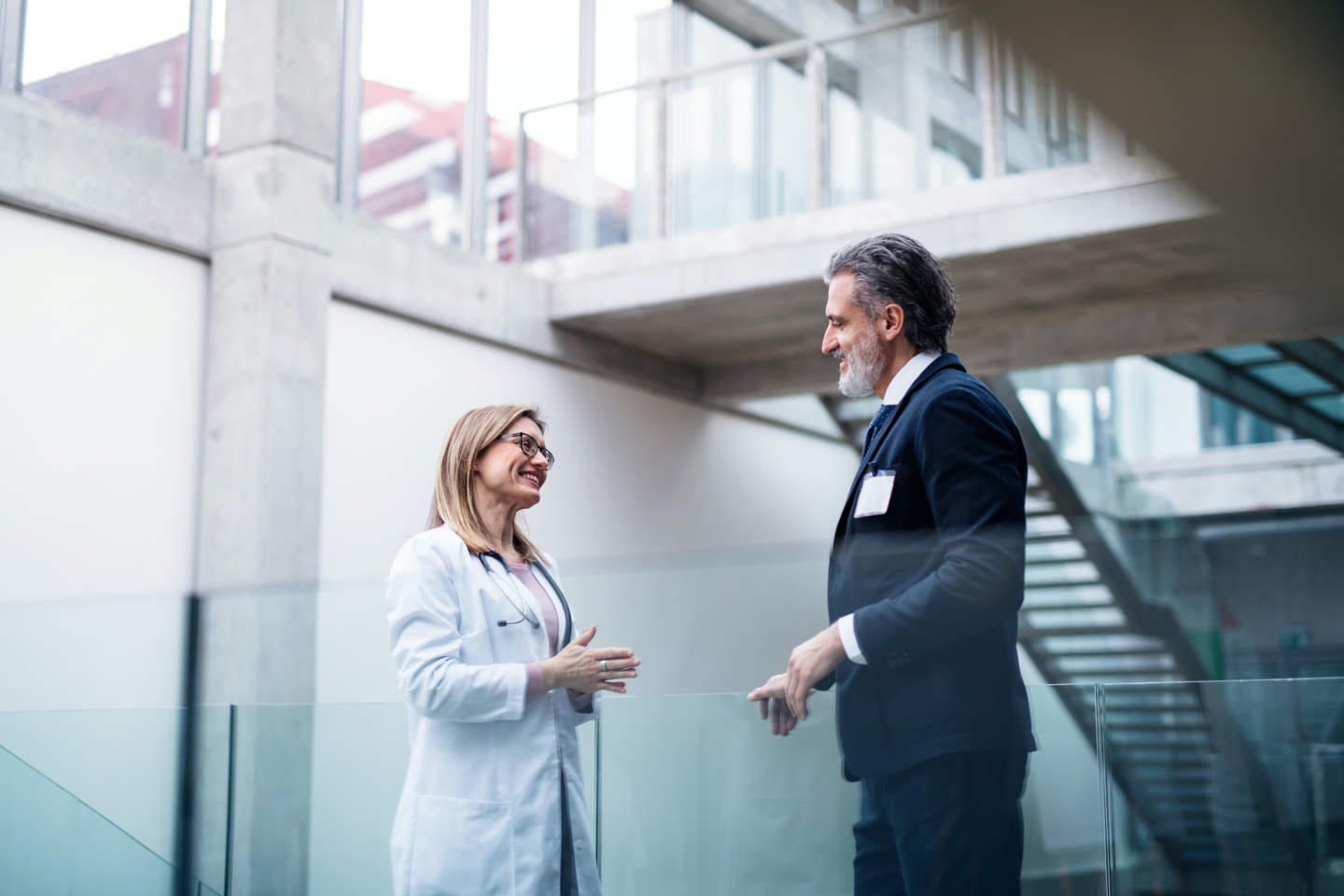 Female doctor talking to pharmaceutical sales representative on conference.