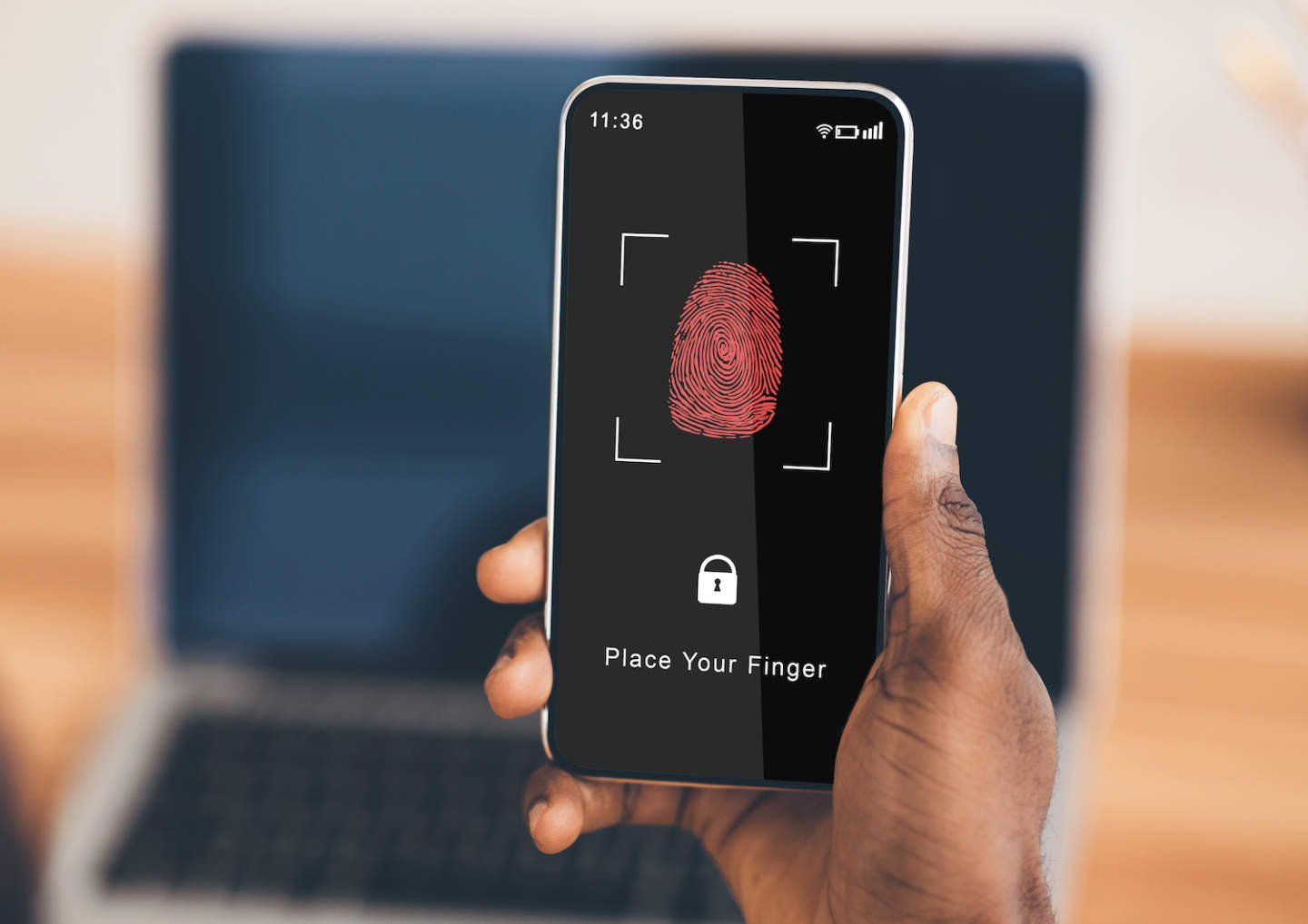 Biometric Authentication Concept. Over The Shoulder View Of Black Guy Holding Smartphone In Hand, Showing App For Fingerprint Scanning With A Zone To Touch With Thumbprint Icon On His Gadget Screen