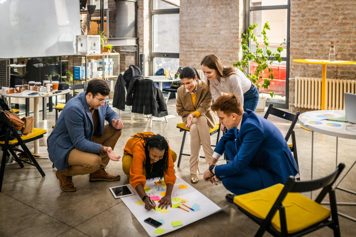Project managers and employees brainstorming on ideas - Multi-ethnic group of workers having business meeting in a start-up office
