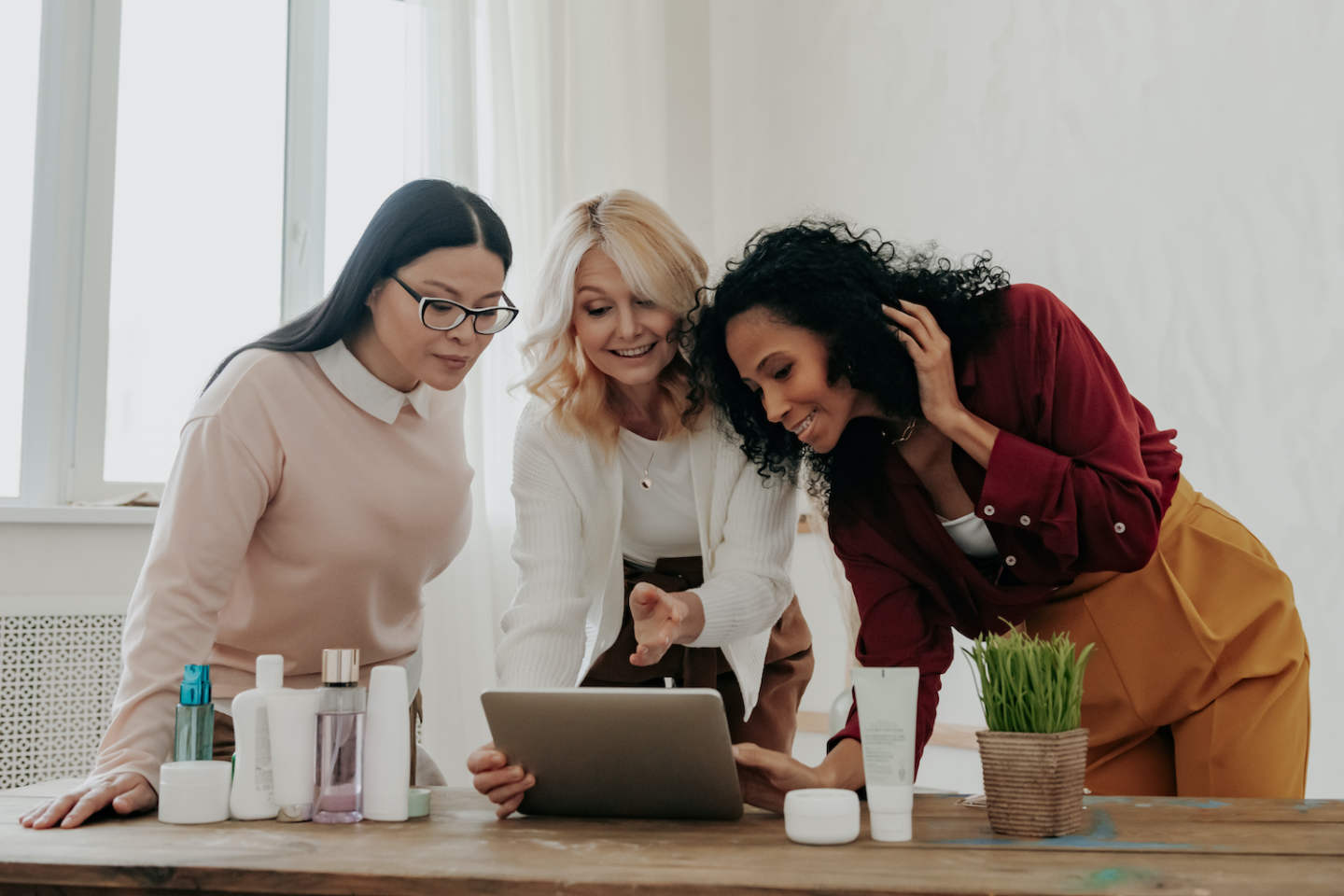 Three mature women buying beauty products online while spending time together