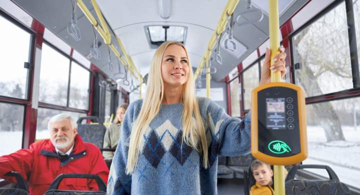 Portrait of young pretty blond woman in blue pullover old gray haired man wearing a red jacket and small boy wearing yellow jacket hurrying to work and school by bus.