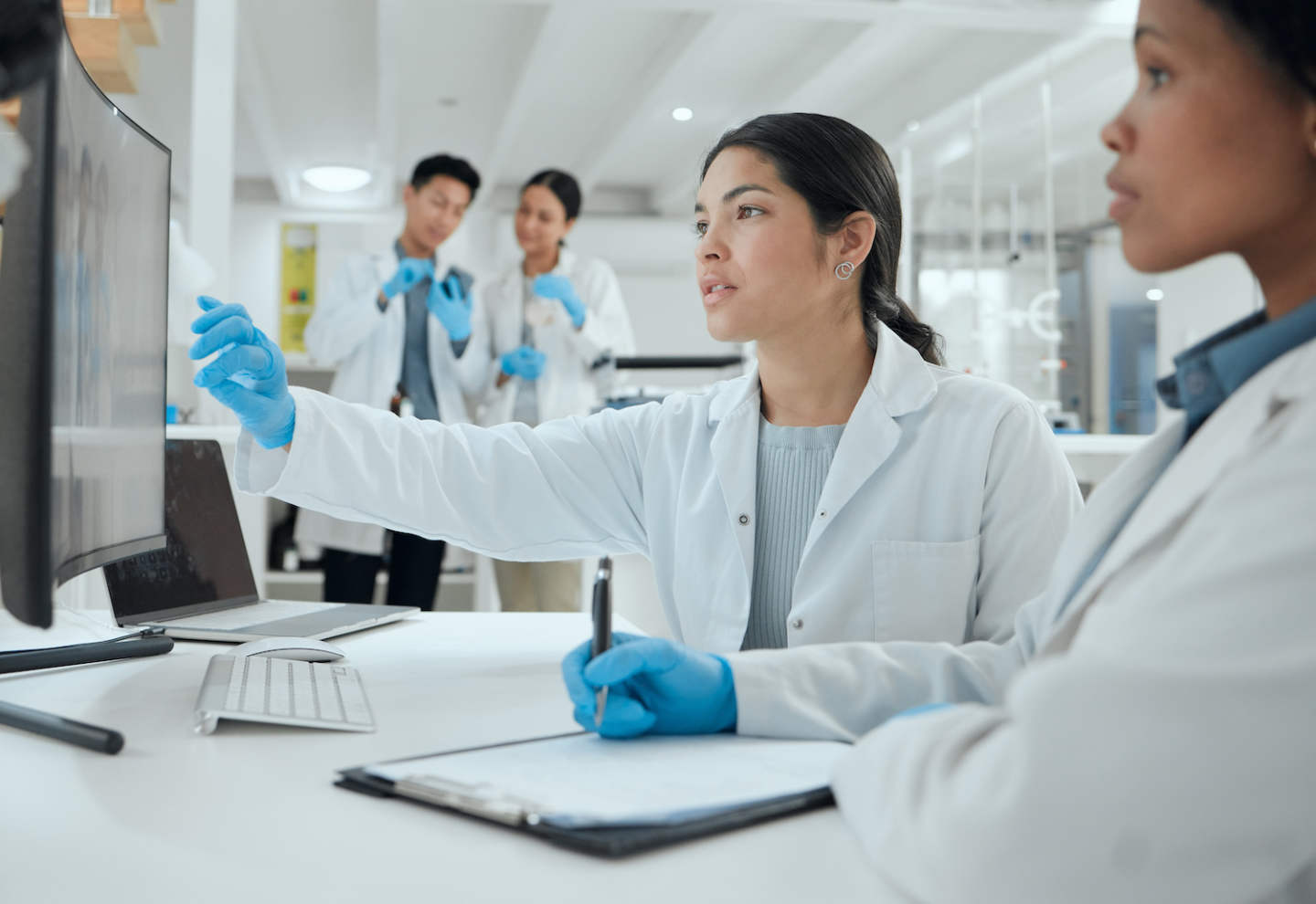 Shot of two scientists helping one another in the lab.