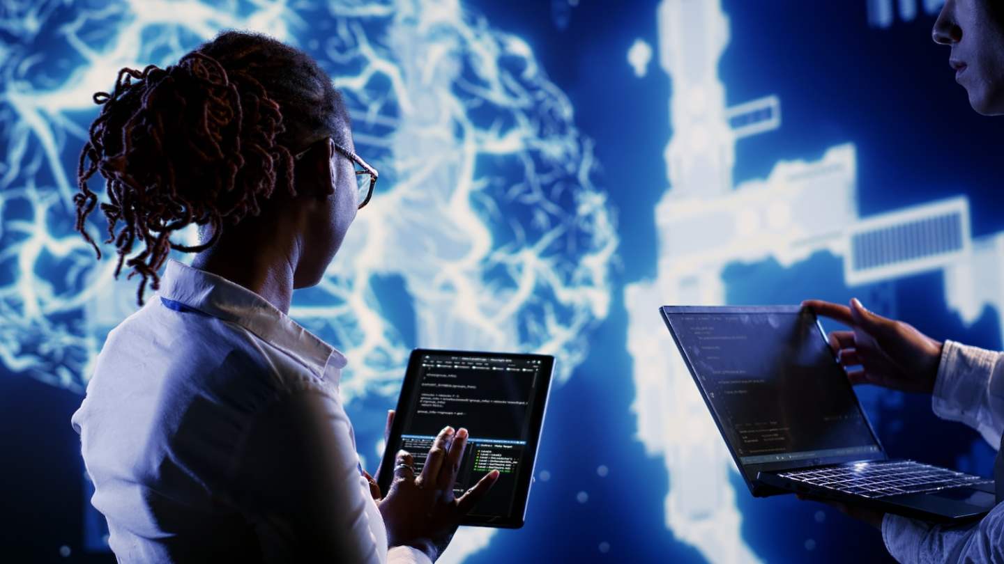 Engineering colleagues develop artificial intelligence neural networks architecture inspired by human brain, setting up AI machine learning algorithms using programming script on tablet