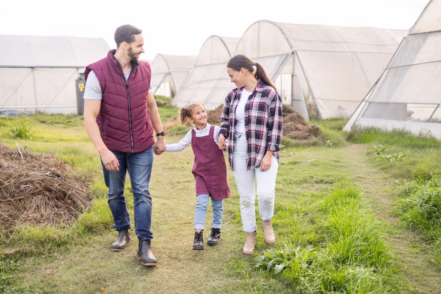 Farming, family and sustainable lifestyle with child and parents walking together on a field for lo.