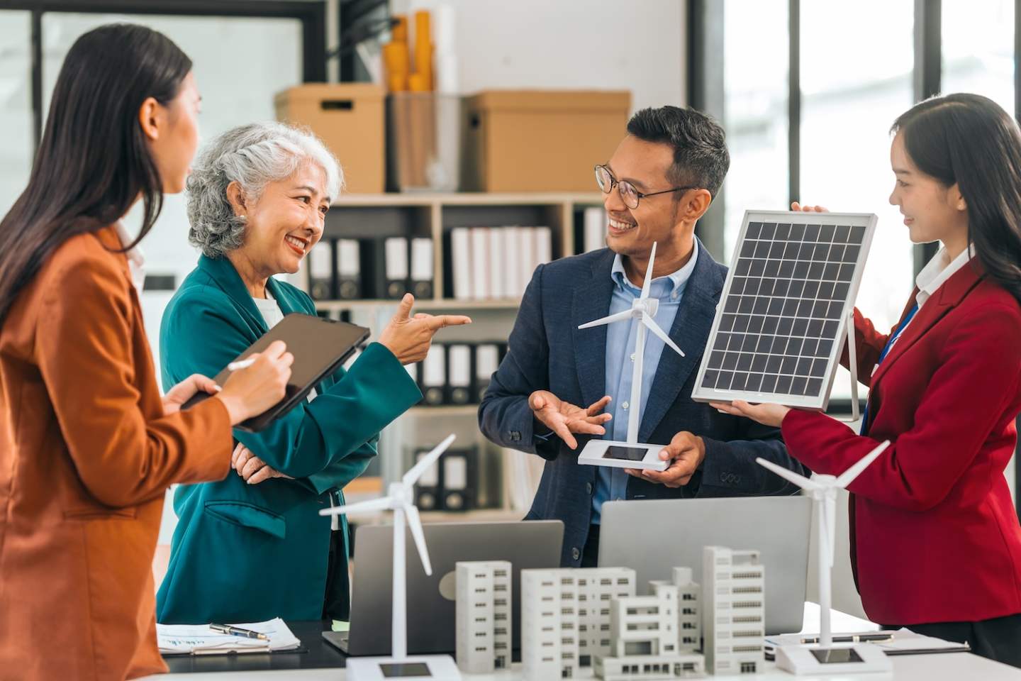 Group asian business people meeting boardroom clean energy city solutions discussing solar panels