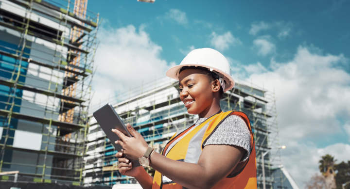Shot of a young woman using a digital tablet while working at a construction site.