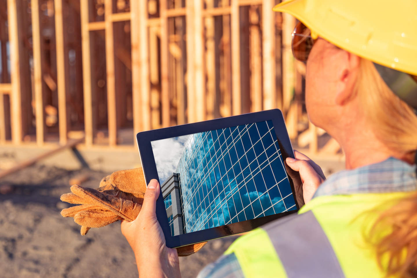 Female Construction Workers Reviewing Building on Computer Pad at Construction Site.