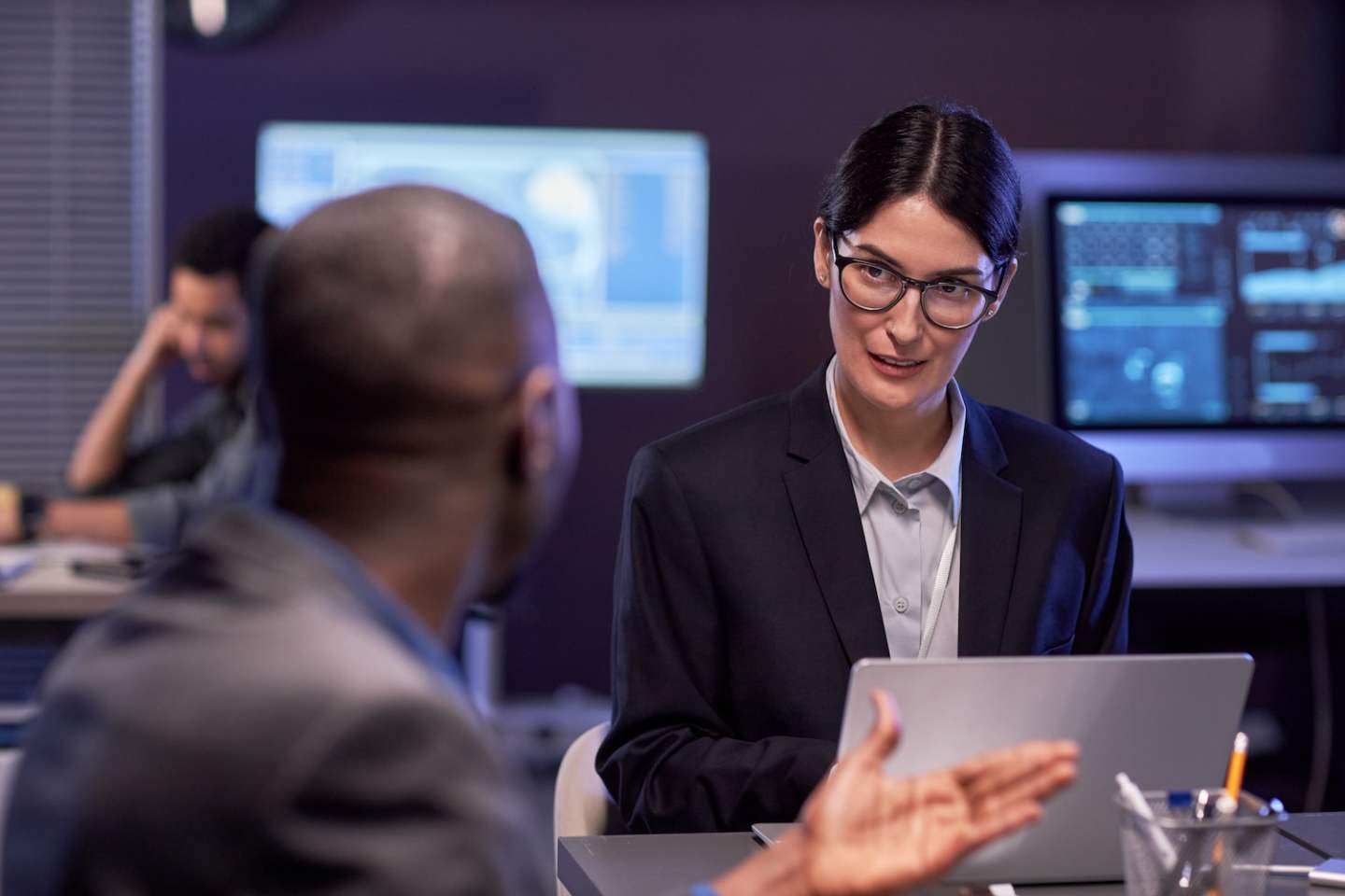 Portrait of serious businesswoman using laptop during meeting in high tech IT security office