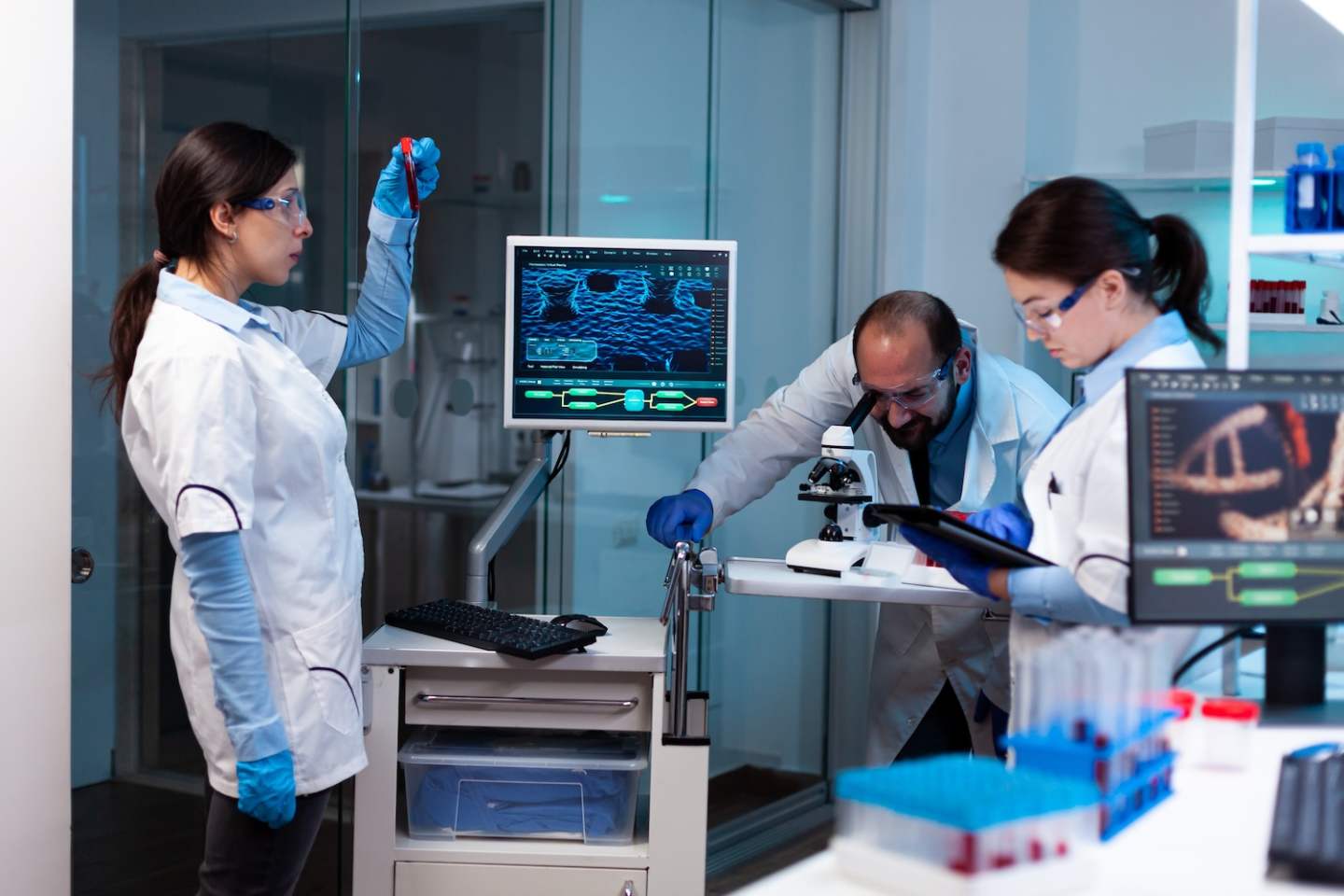 Team of medical research scientists conducting vaccine development , test tube, blood sample. Chemists in pharmaceutical lab examining sample for medical experiment with technology for medicine industry.