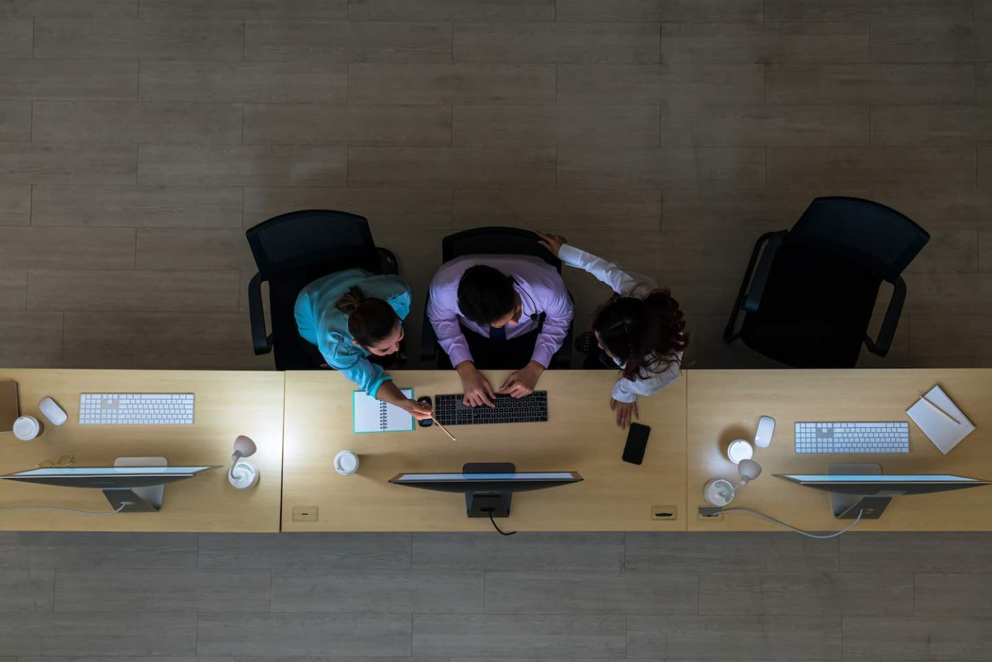 Top view of Three Asian customer care service working hard late in night shift at office,call center department,worker and overtime,team work with colleagues for success concept