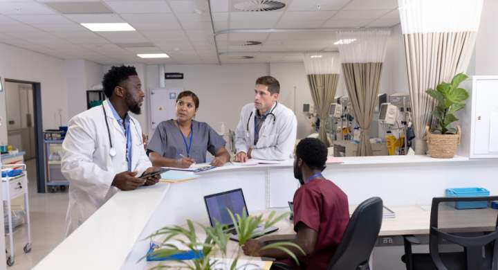 Diverse doctors and medical staff talking at reception desk of hospital ward. Hospital, teamwork, medical and healthcare services.