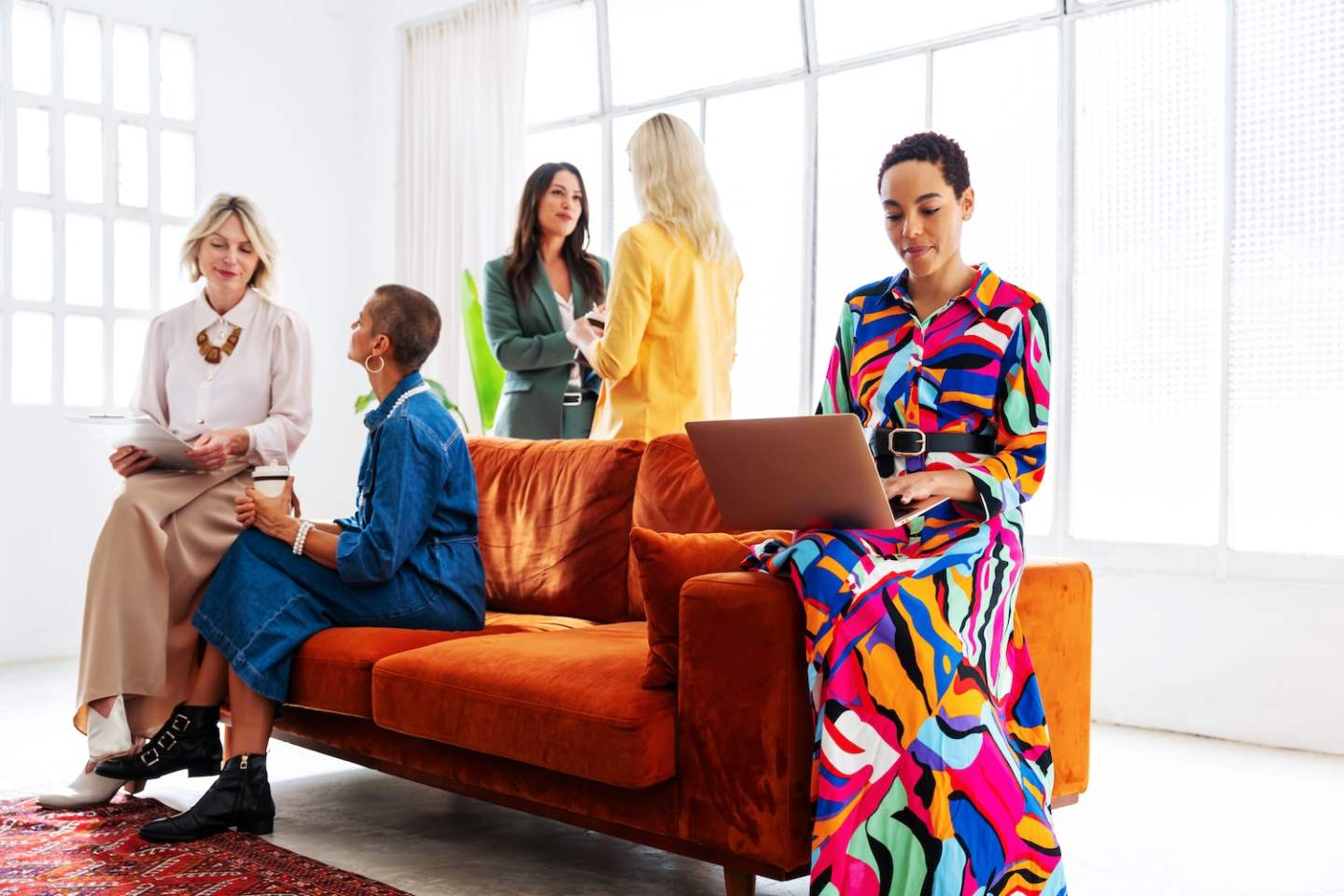 Group of beautiful confident businesswomen meeting in the office - Multiethinc female creative team brainstorming at work - Diverse colleagues working together in workshop in a co-working space