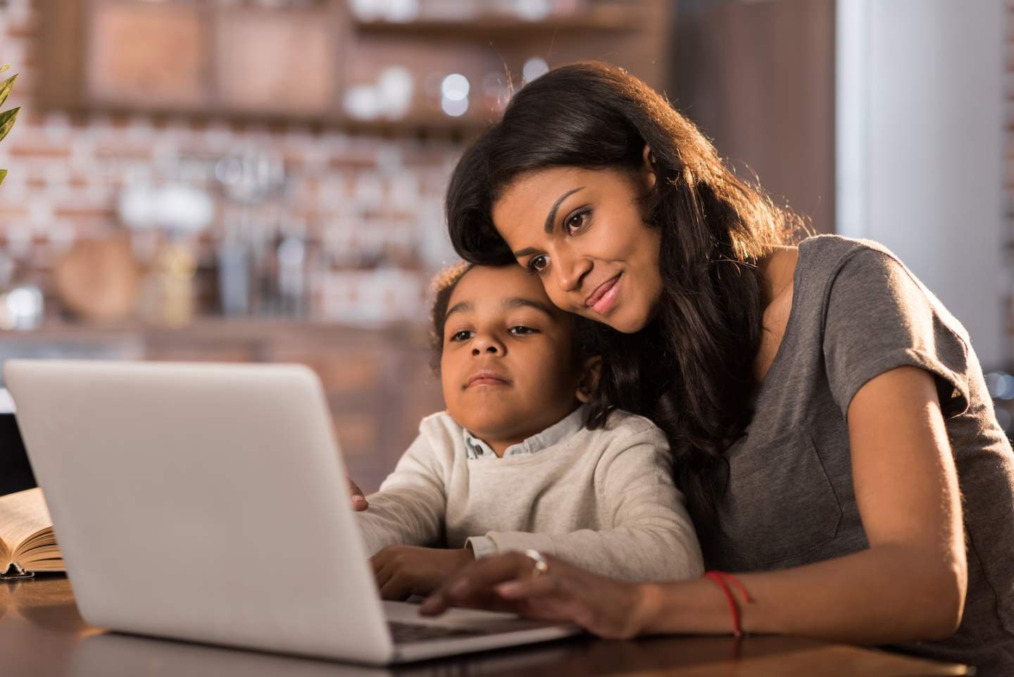 portrait of smiling mother and daughter using laptop at home