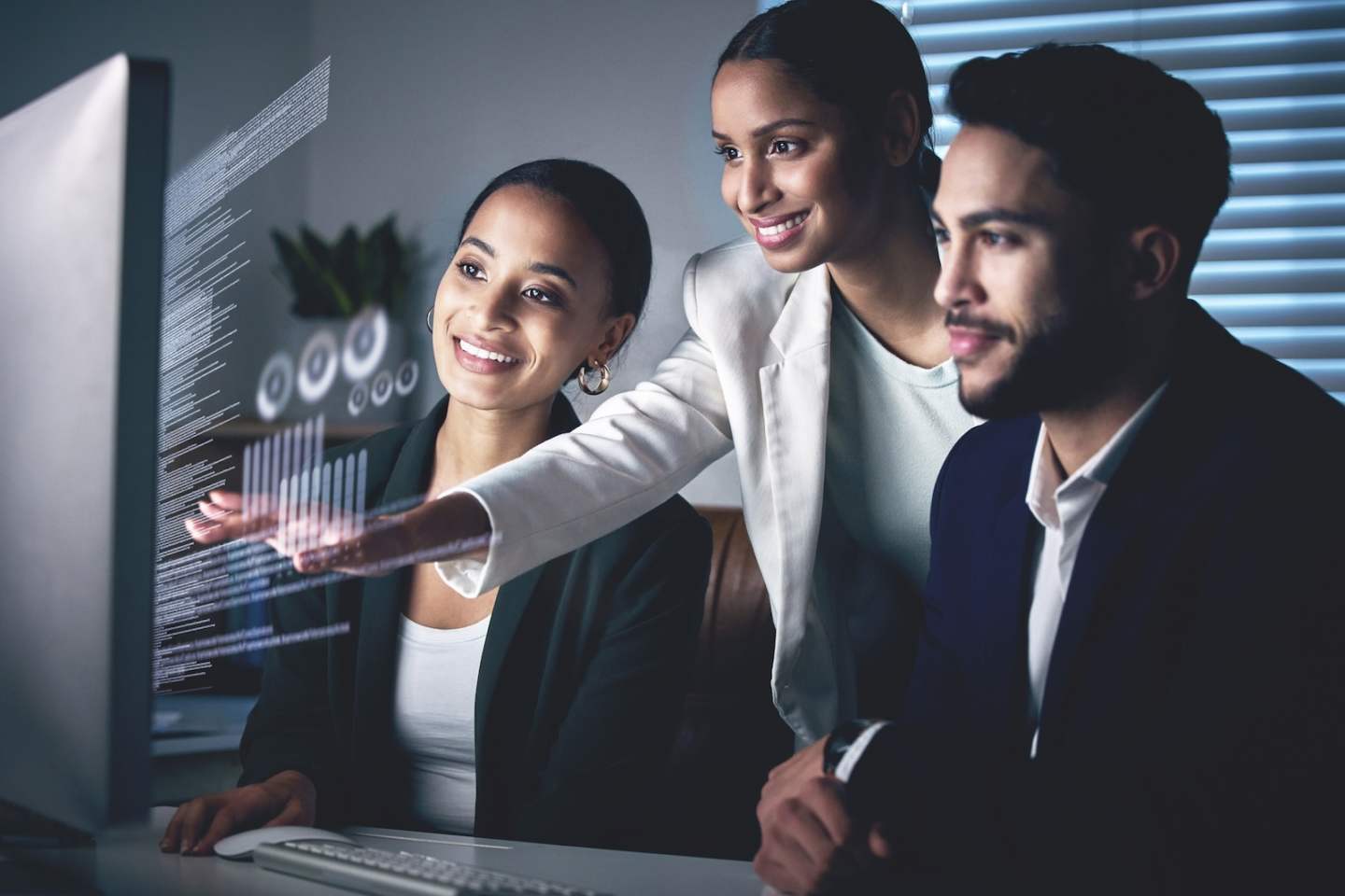 Shot of a young group of businesspeople using a computer while working in the office at night.