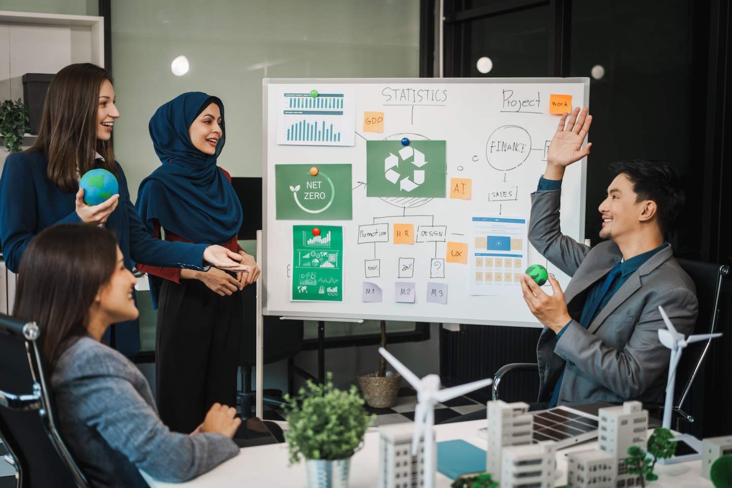 Diverse team, middle-aged Asian businessman, Caucasian young businesswoman, Muslim hijab-wearing