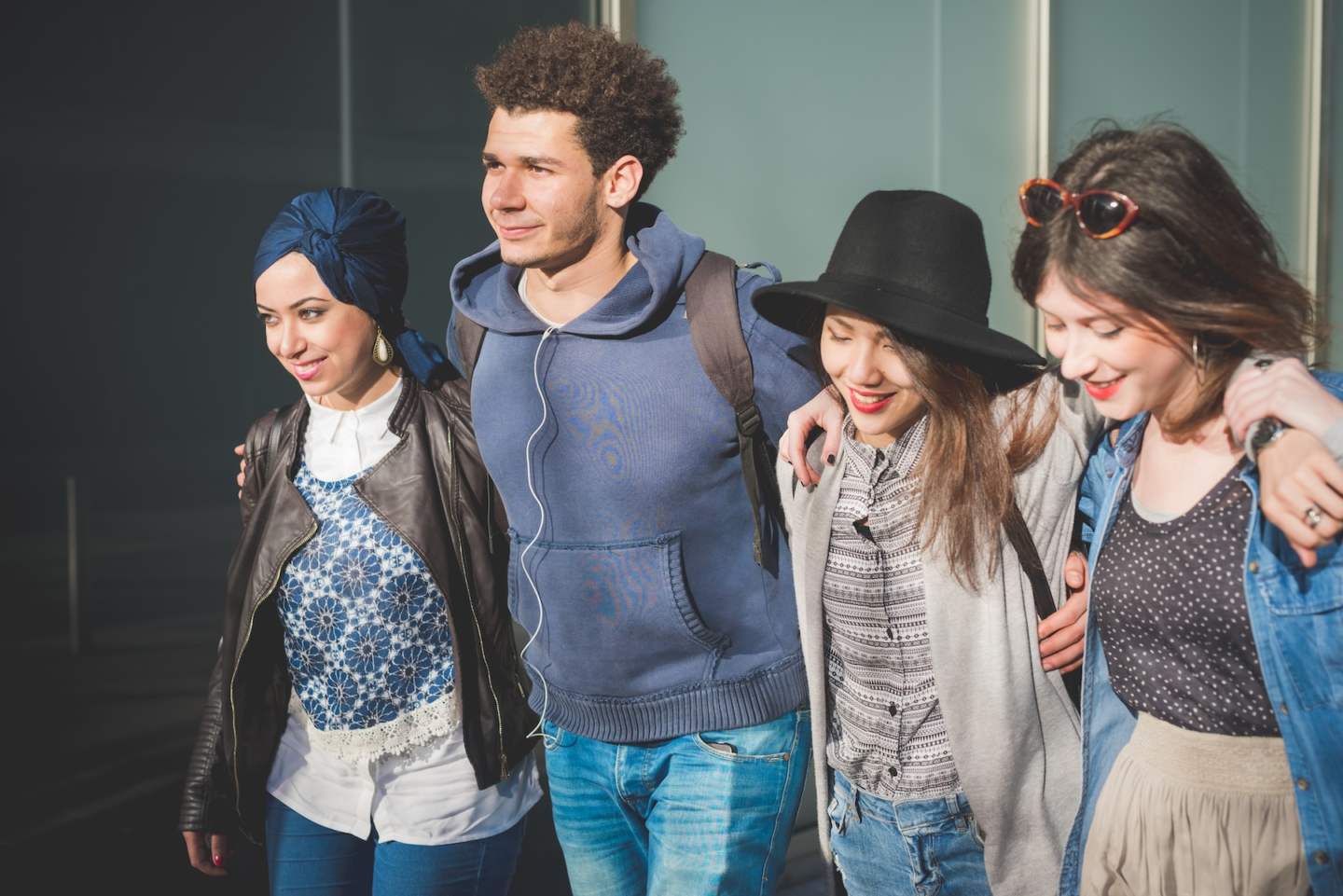 group of friends walking together and hugging – closeness, diversity, cheerful