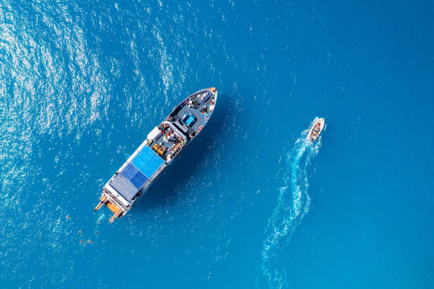 Aerial view of beautiful yacht and boat on the sea at sunset in summer. Lefkada island, Greece. Top view of luxury yachts,motorboat, clear blue water. Travel. Cruise vacation. Yachting. Seascape