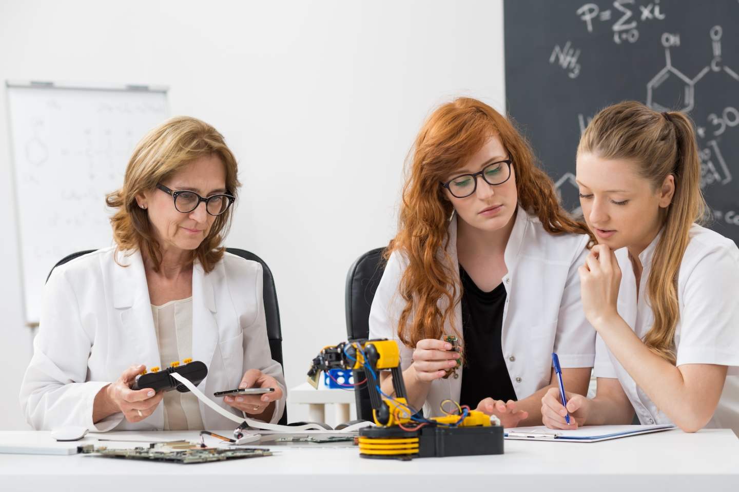 Shot of technical university teacher working on a new project with her students