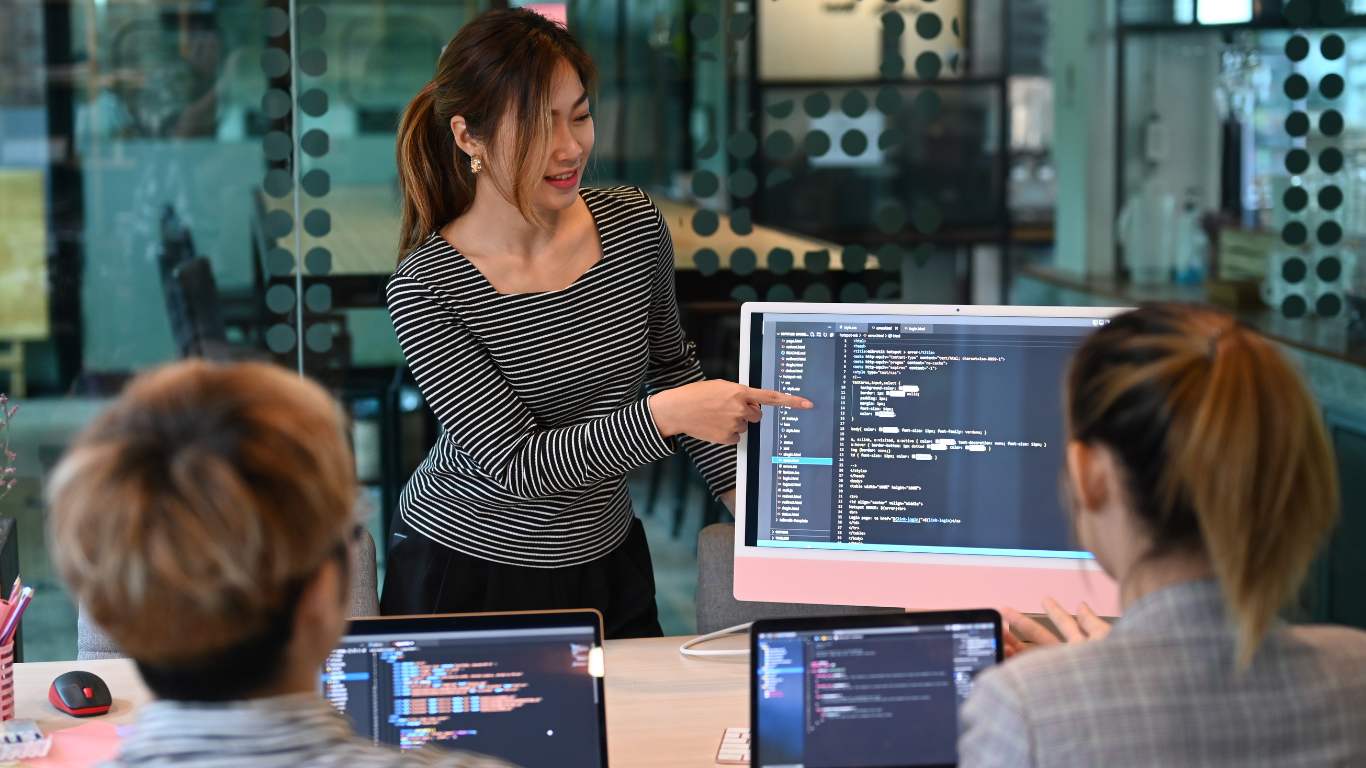 Woman teaching coding to her juniors through AI