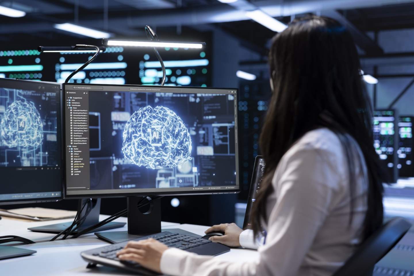 Engineer working in data center providing computing resources needed for artificial intelligence to process massive datasets for training. Woman in server room storing data used for machine learning