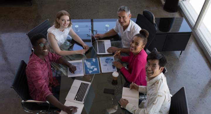 Portrait of diverse business colleagues working together and looking over graphs in modern office