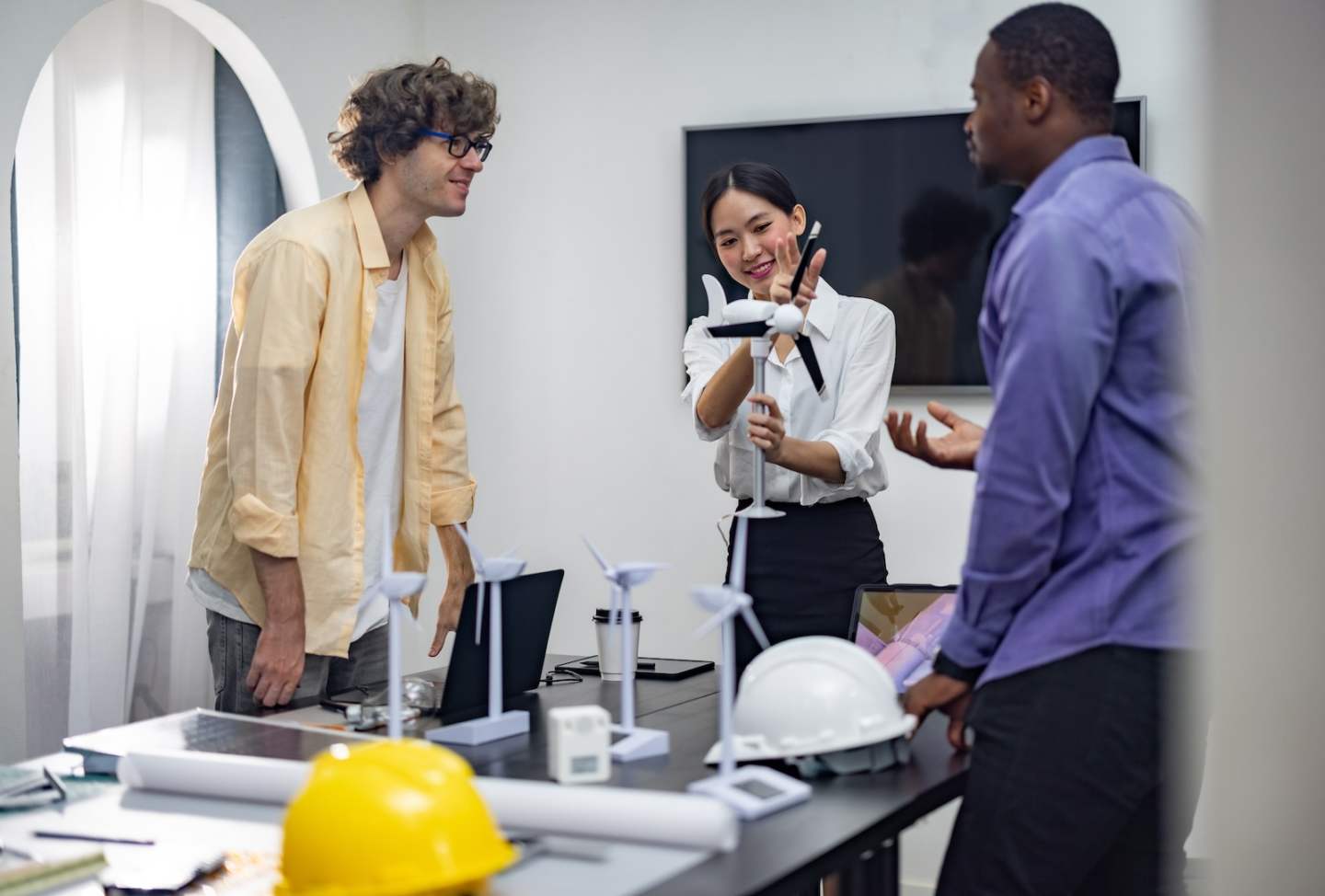 A diverse startup team develop, collaborates on a powerful, lightweight, portable wind turbine prototype, aligning with potential user demand and renewable energy needs to secure investor funding.