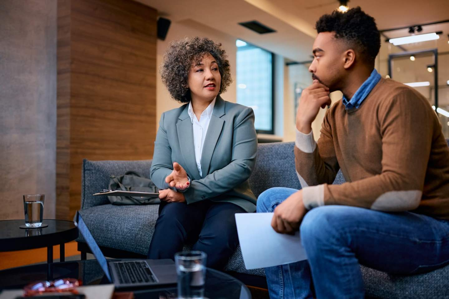 Financial advisor talking to African American man during meeting in her office.