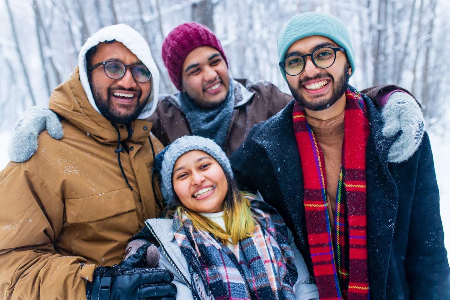 four people taking selfie shot outdoors at new year holidays.