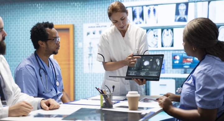 Team of specialists reviewing ecg results in a meeting at a private clinic, analyzing cardiovascular system on a radiography for disease prevention. Consulting cardiac scans and records.