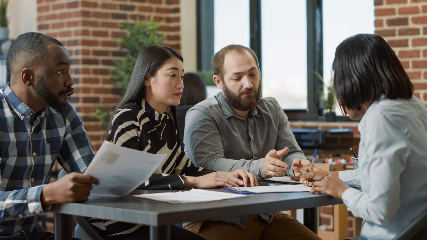 Displeased worker getting fired by multiethnic group of people, feeling sad about lost work and career. Female employee feeling angry about failure, losing job and being discharged.