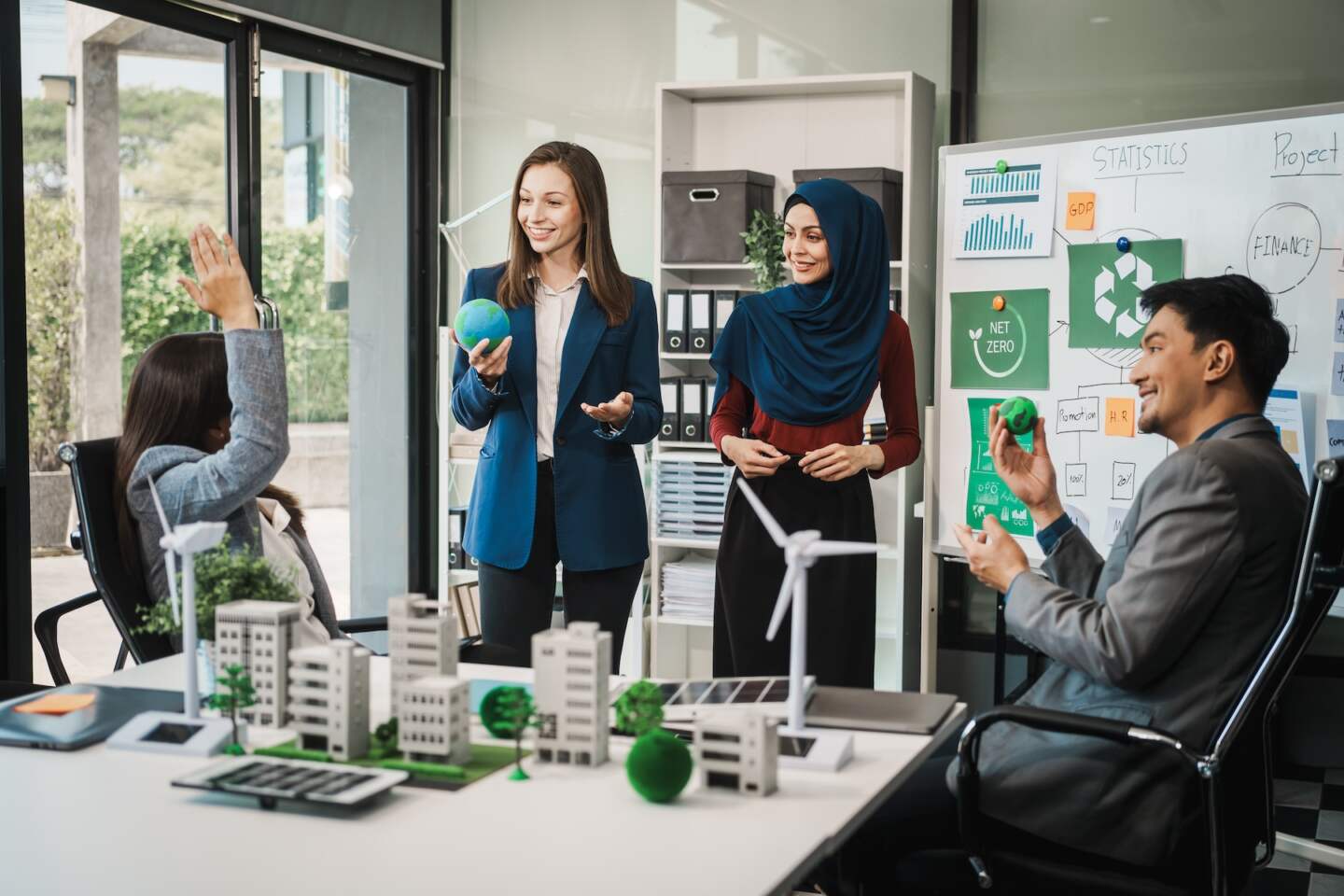 Diverse team, middle-aged Asian businessman, Caucasian young businesswoman, Muslim hijab-wearing