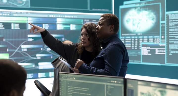 Governmental hackers analyzing cyber threats on big screens, managing important database hacking activity in high tech agency office. Work on cyber defense to protect national security.