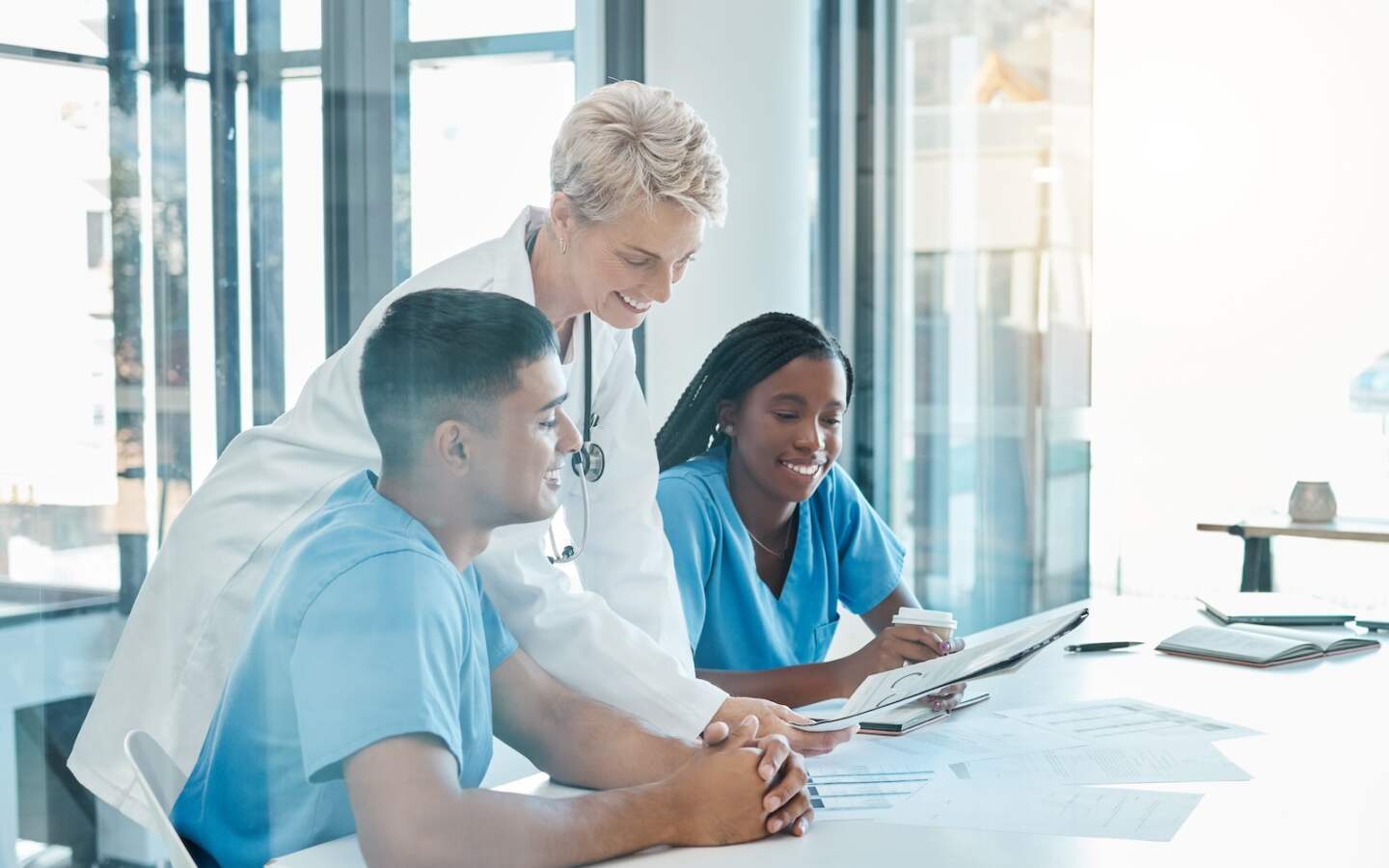 Happy healthcare doctors and nurses in a meeting together in conversation about healthy patients an.