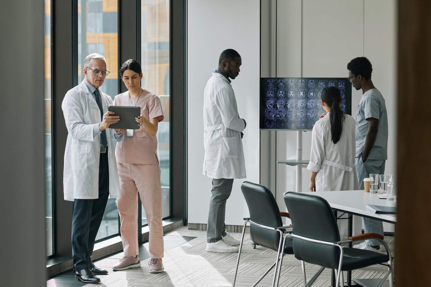 Wide angle view at diverse group of doctors in conference room, copy space
