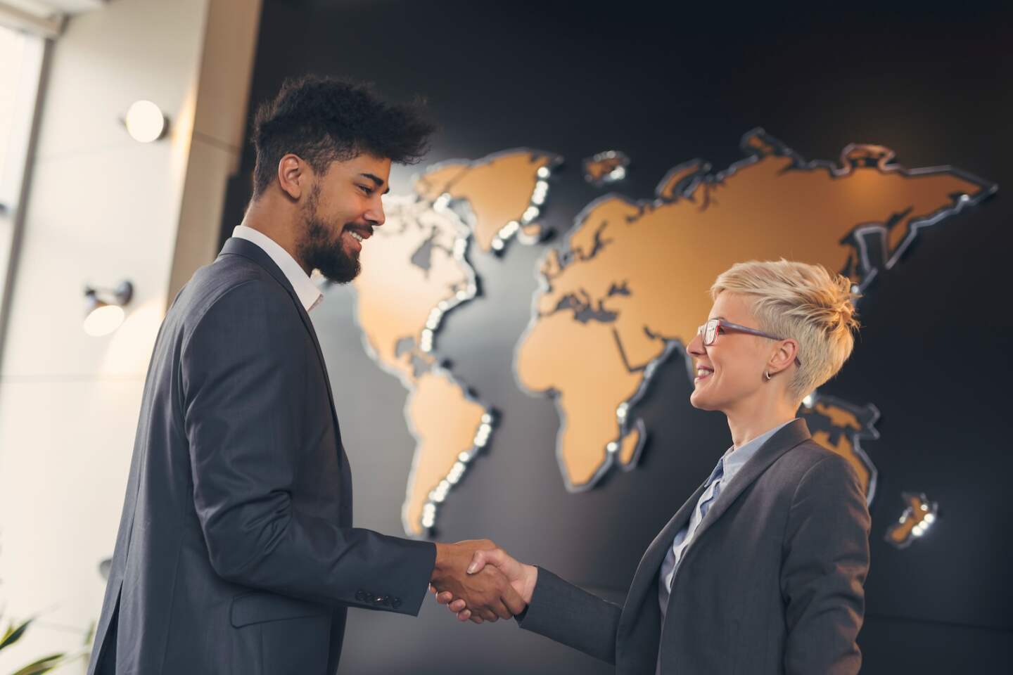 Businessman and business woman shaking hands after achieving agreement and signing contract. Focus on the woman