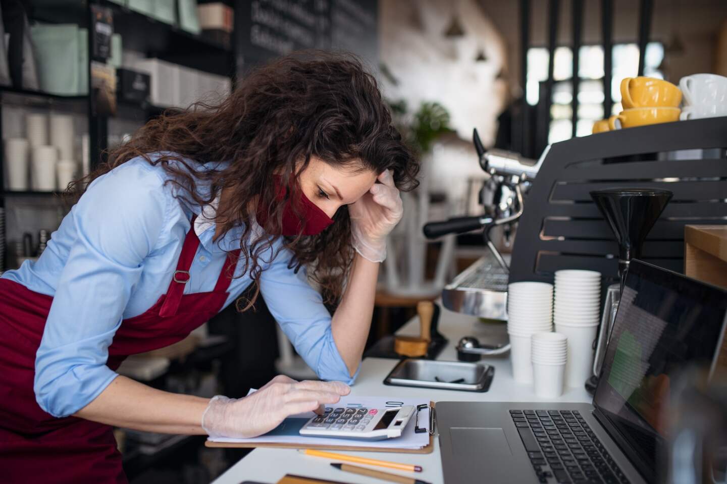 A frustrated coffee shop manager discussing issues with waitress in cafe, small business and new normal concept.