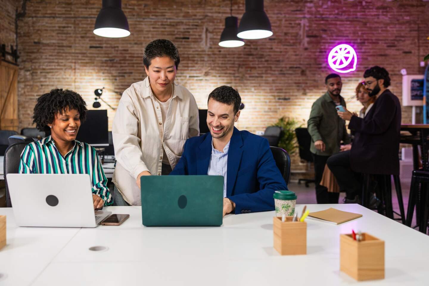 Business colleagues working together on laptops, demonstrating teamwork and collaboration in a contemporary office space